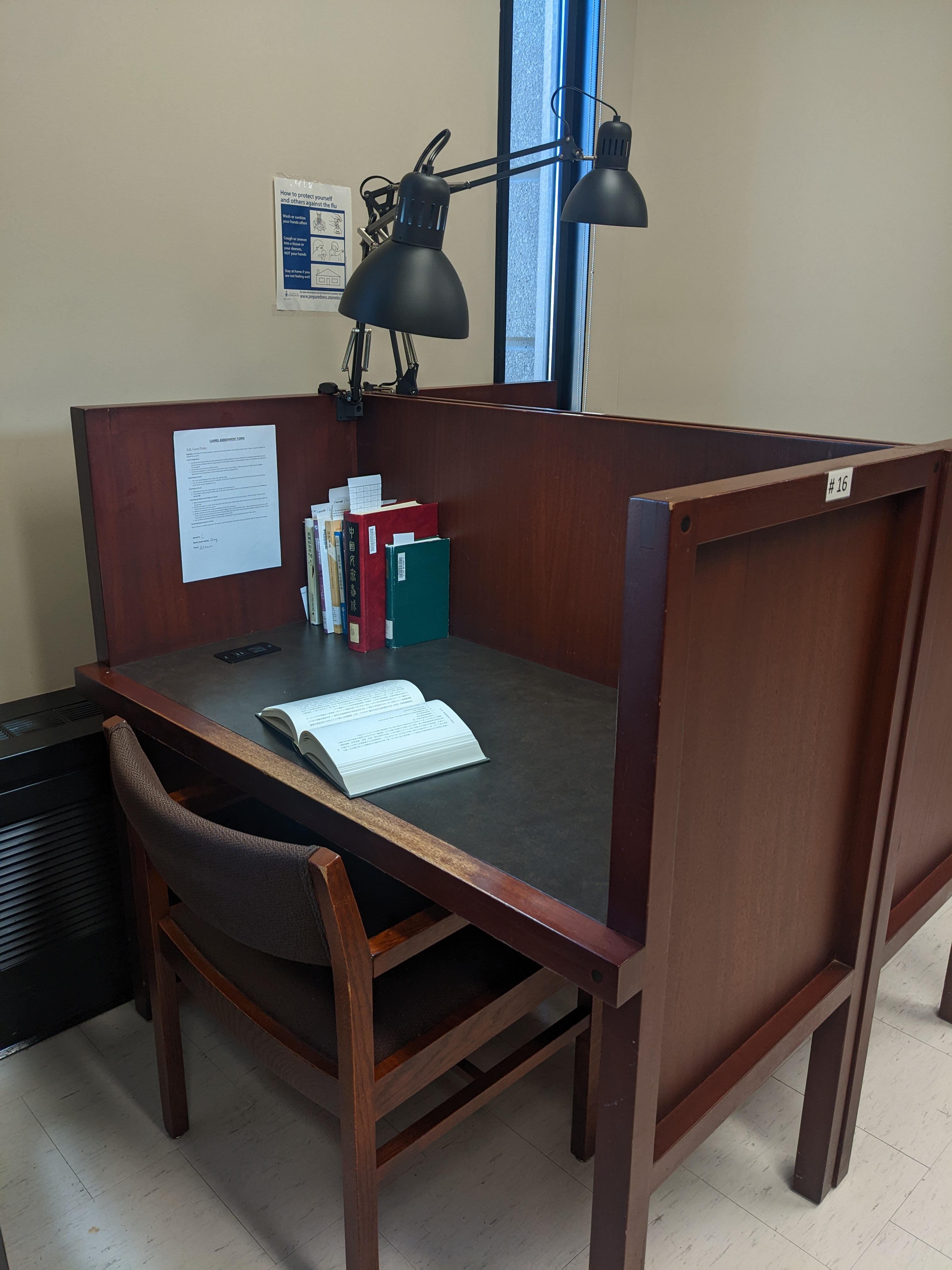 Image of a desk with new task lighting in EAL study carrels shining light on books on desk.