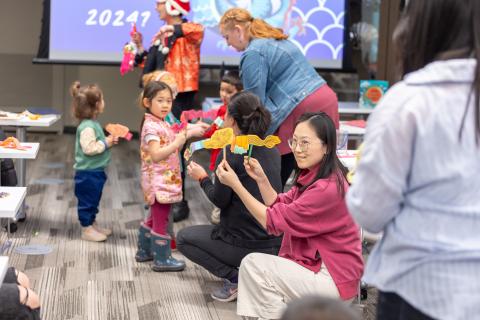 A charming dragon parade featuring creations crafted by attendees, depicts children showcasing their dragons at the Cheng Yu Tung East Asian Library..