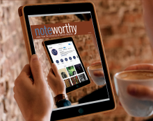 An image of a person holding a tablet with an image of the newsletter cover on the screen